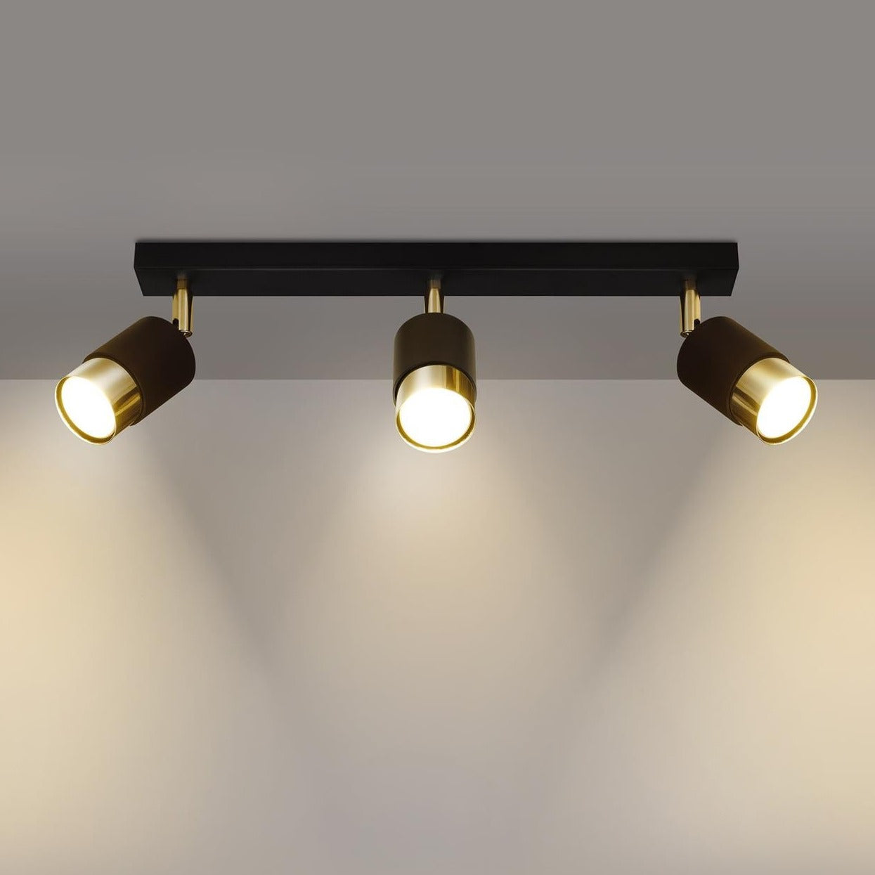 Three-light Trip Track Light in gold and black, providing adjustable focused lighting, suitable for ceiling or wall installation in various rooms