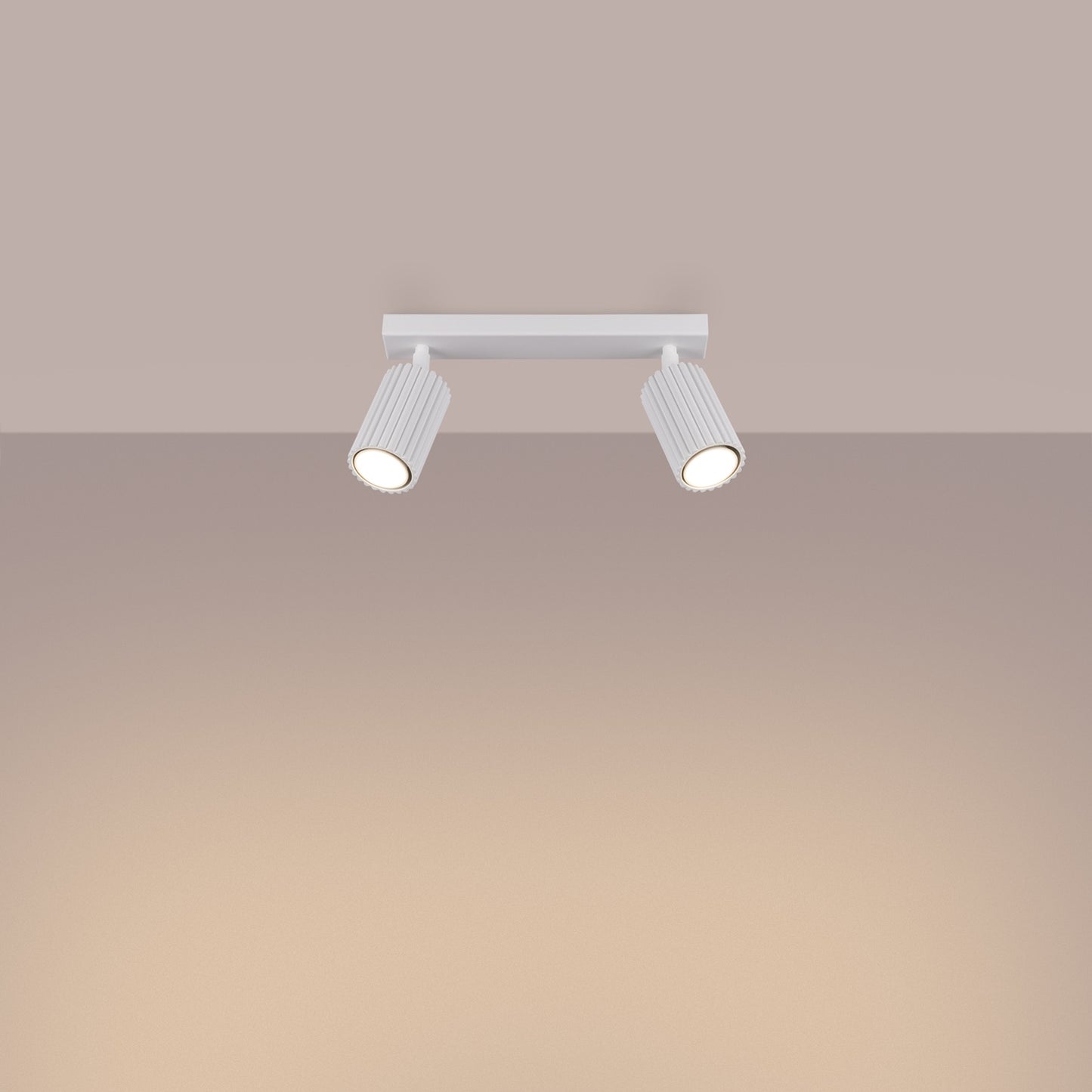 White Twin Ribbed Surface Spotlight switched on in modern UK home interior, warm LED glow