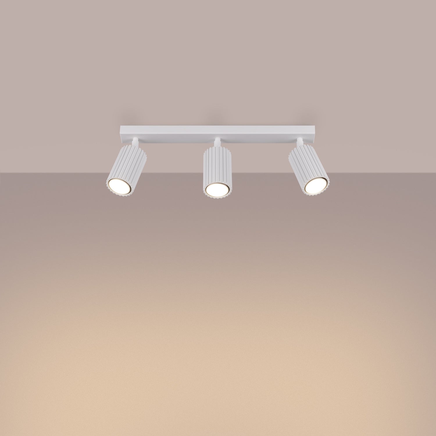 White Triple Ribbed Spotlight Bar switched on in modern UK home interior, warm LED glow