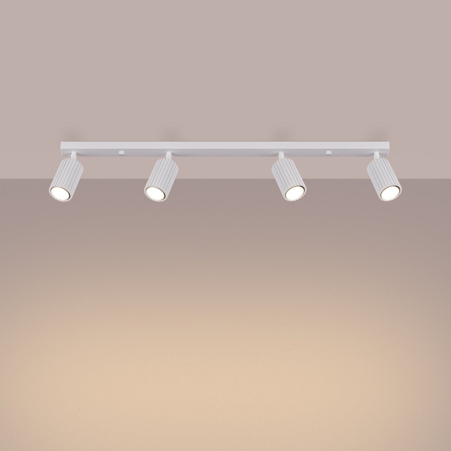 White Four Light Ribbed Spotlight Bar switched on in modern UK home interior, warm LED glow