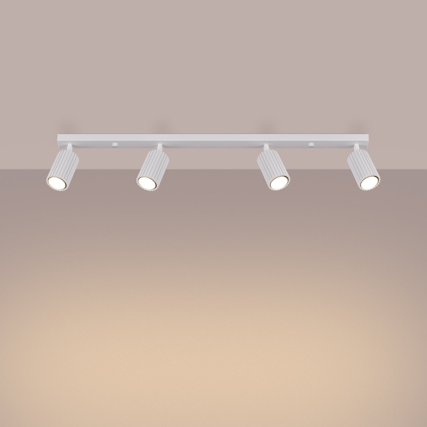 White Four Light Ribbed Spotlight Bar switched on in modern UK home interior, warm LED glow