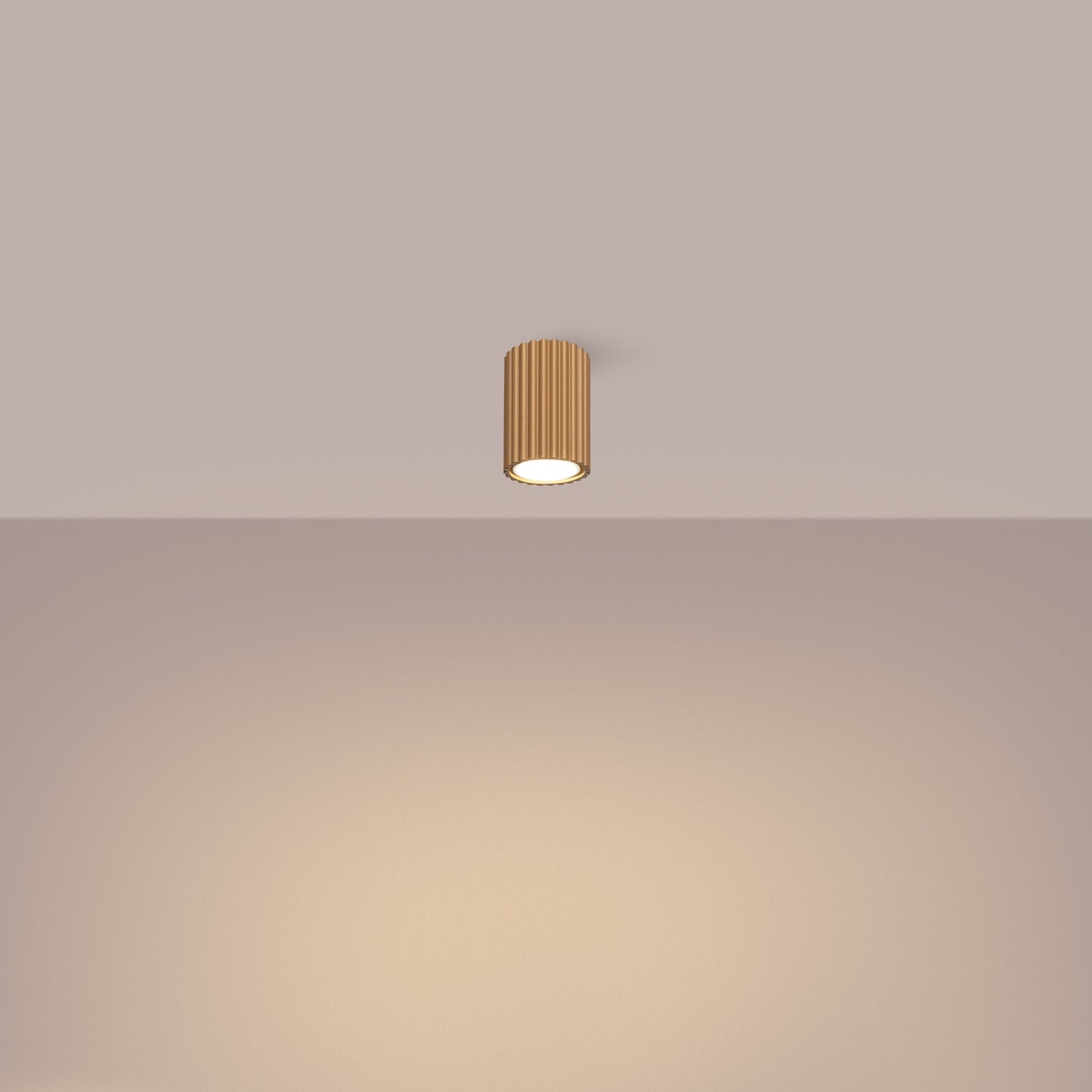 Gold Ribbed Surface Spotlight switched on in modern UK home interior, warm LED glow