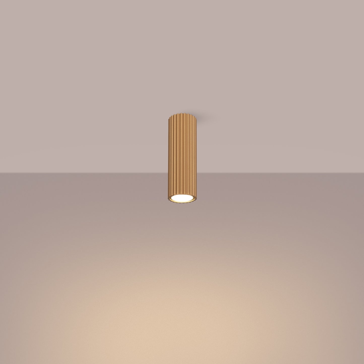 Gold Ribbed Tube Ceiling Spotlight 20cm switched on in modern UK home interior, warm LED glow