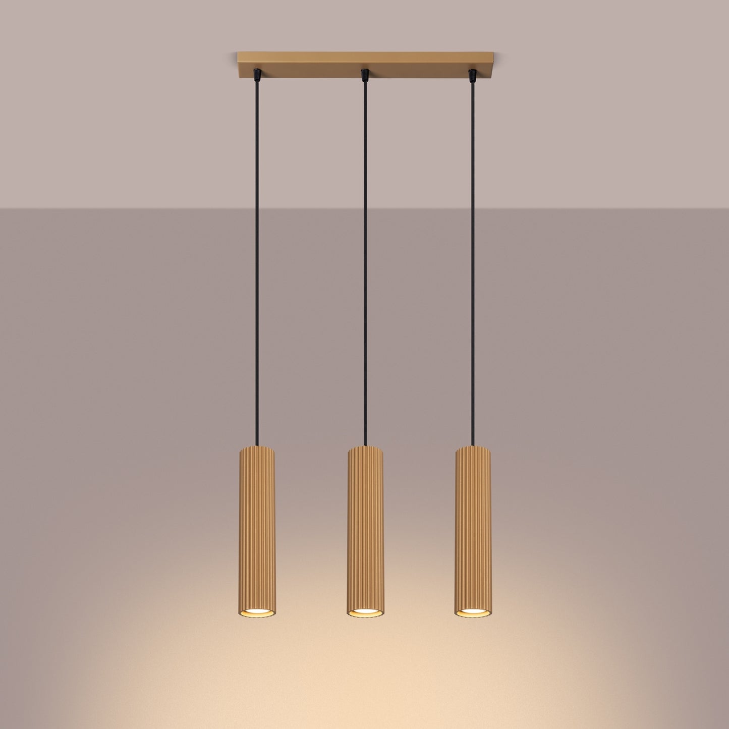 Gold Triple Ribbed Pendant Bar switched on in modern UK home interior, warm LED glow