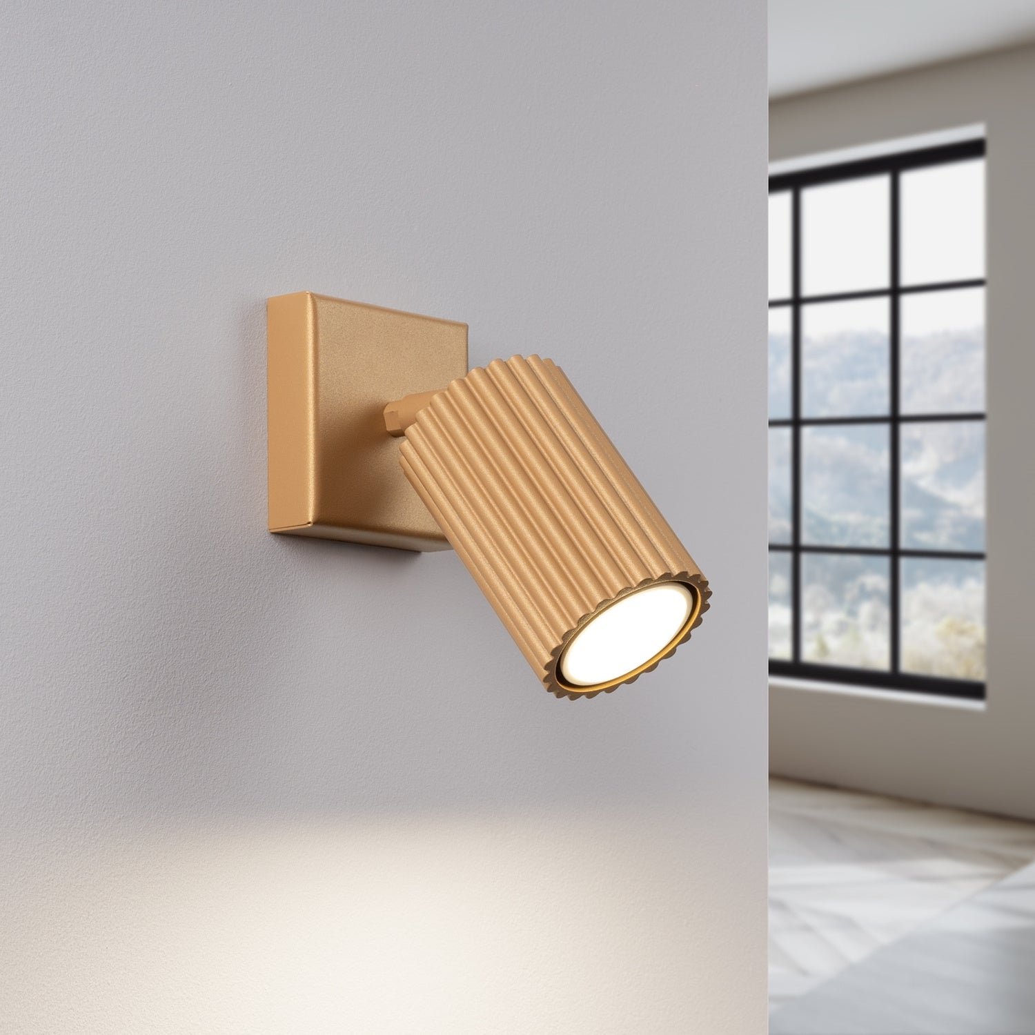 Gold Ribbed Tube Wall Light switched on in modern UK home interior, warm LED glow