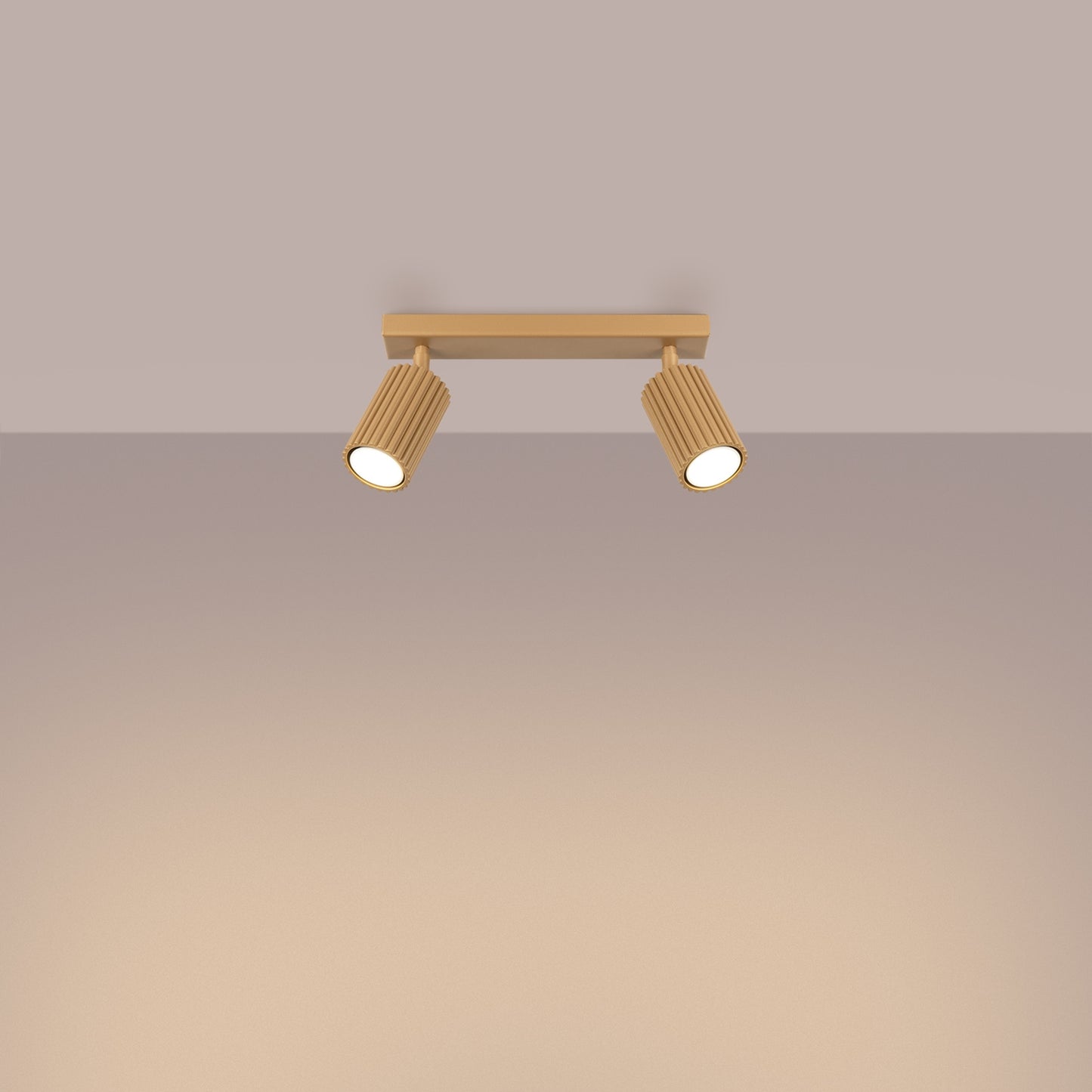 Gold Twin Ribbed Surface Spotlight switched on in modern UK home interior, warm LED glow