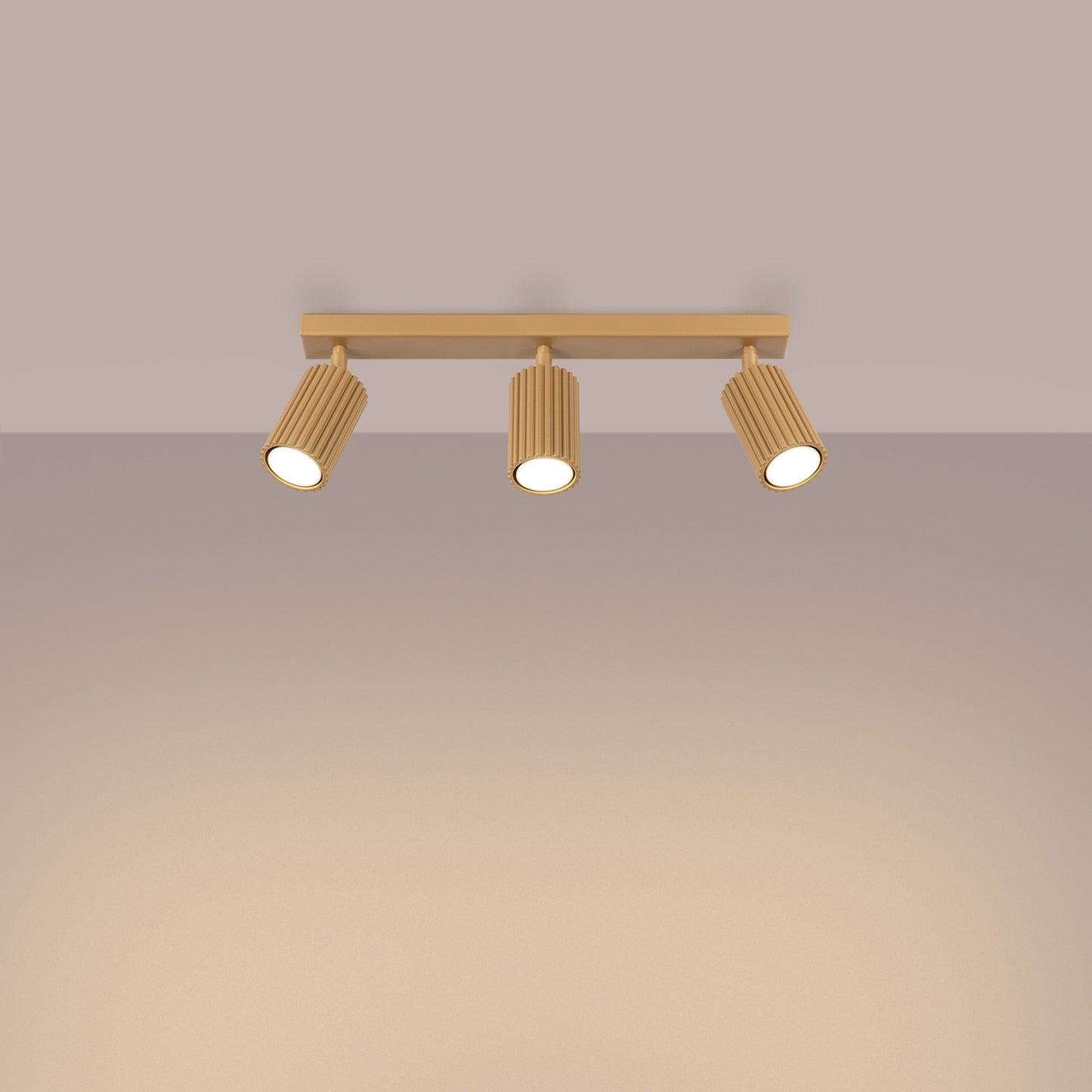 Gold Triple Ribbed Spotlight Bar switched on in modern UK home interior, warm LED glow