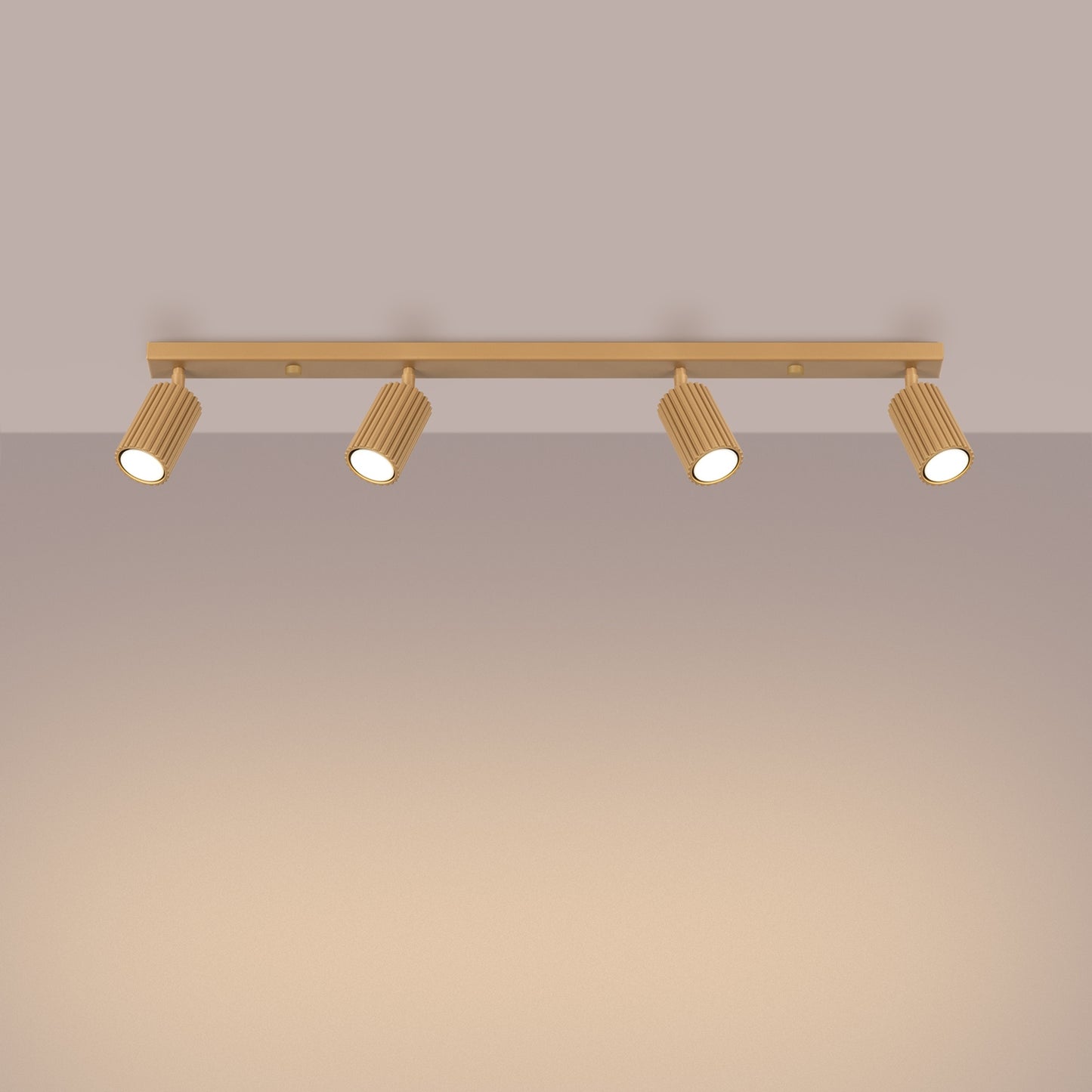 Gold Four Light Ribbed Spotlight Bar switched on in modern UK home interior, warm LED glow