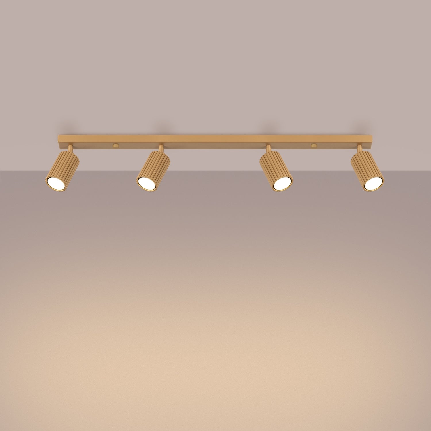 Gold Four Light Ribbed Spotlight Bar switched on in modern UK home interior, warm LED glow