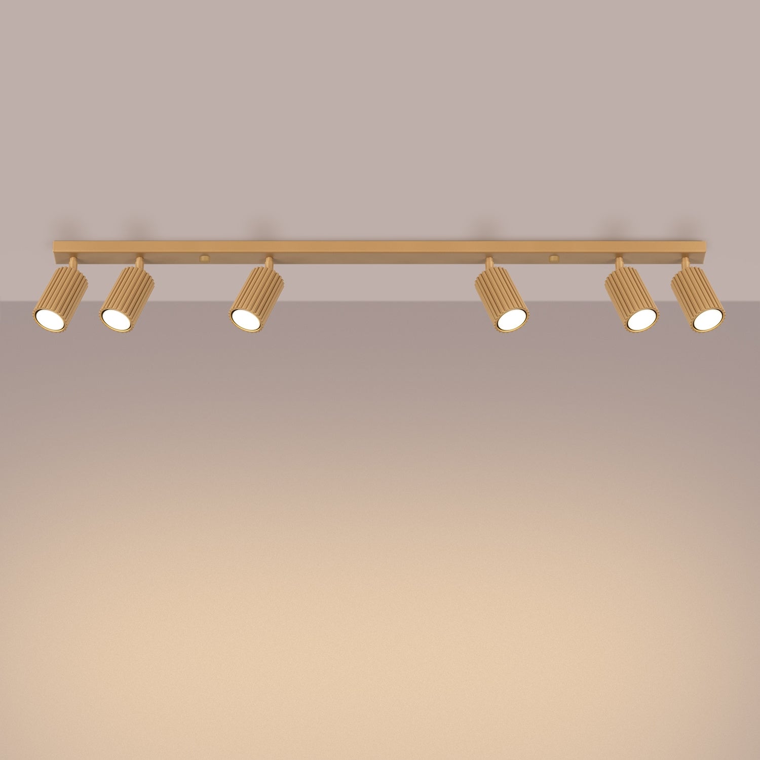 Gold Six Light Ribbed Spotlight Bar switched on in modern UK home interior, warm LED glow