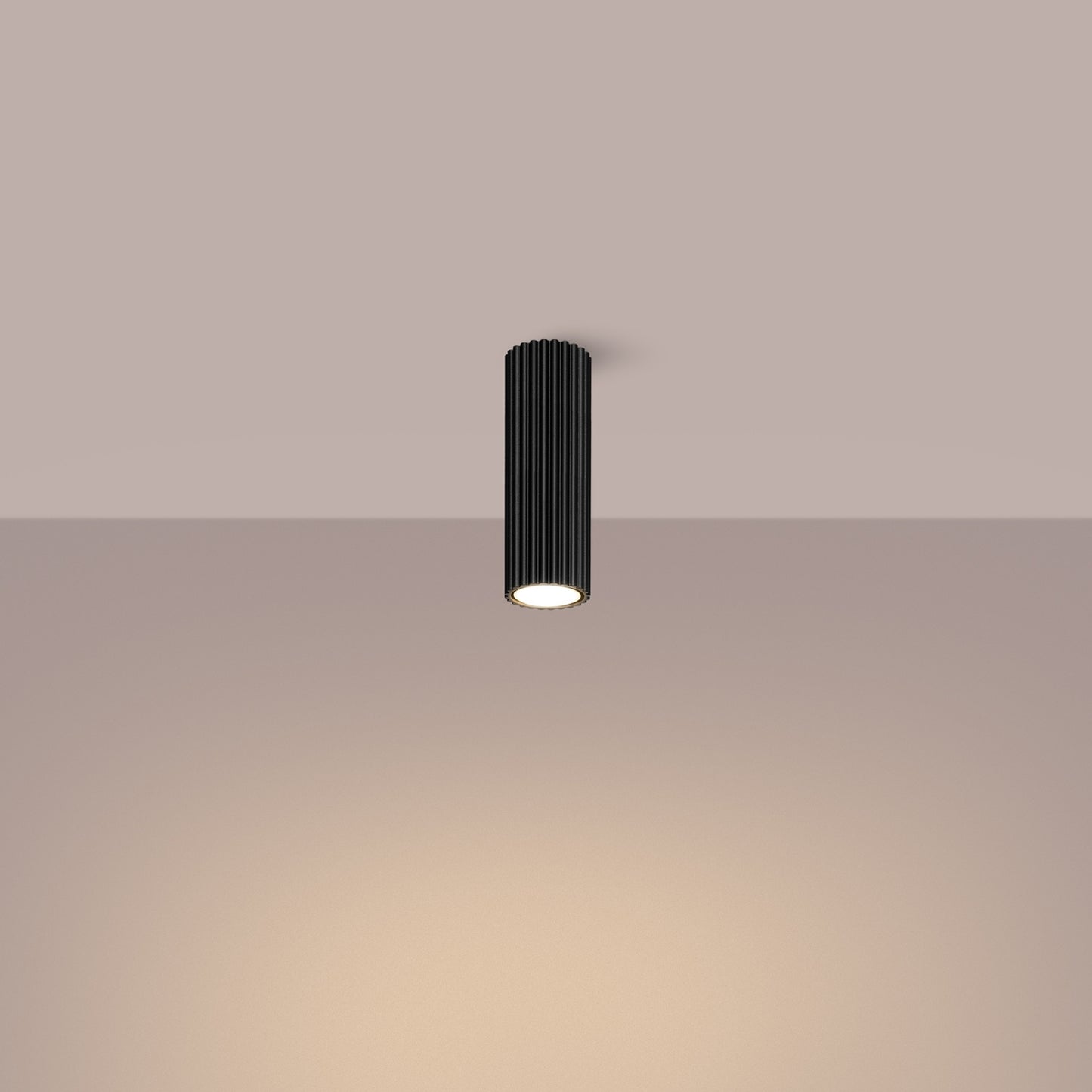 Black Ribbed Tube Ceiling Spotlight 20cm switched on in modern UK home interior, warm LED glow