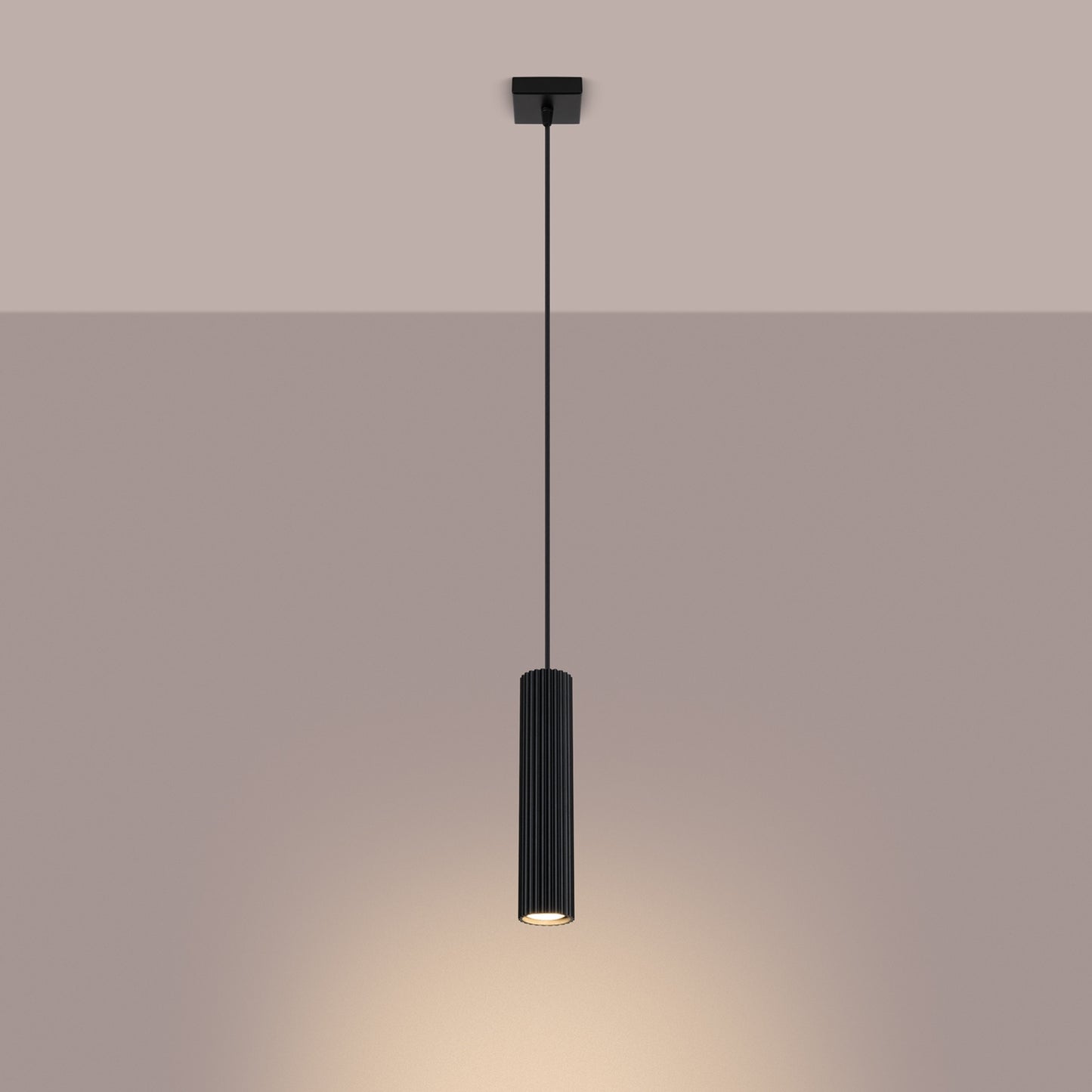 Black Ribbed Cylinder Pendant Light switched on in modern UK home interior, warm LED glow