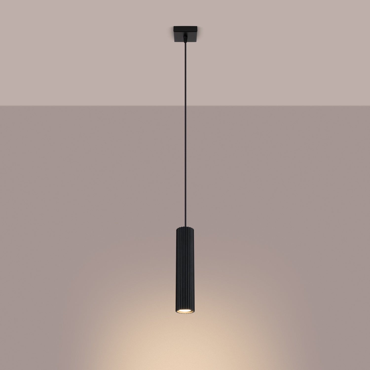 Black Ribbed Cylinder Pendant Light switched on in modern UK home interior, warm LED glow