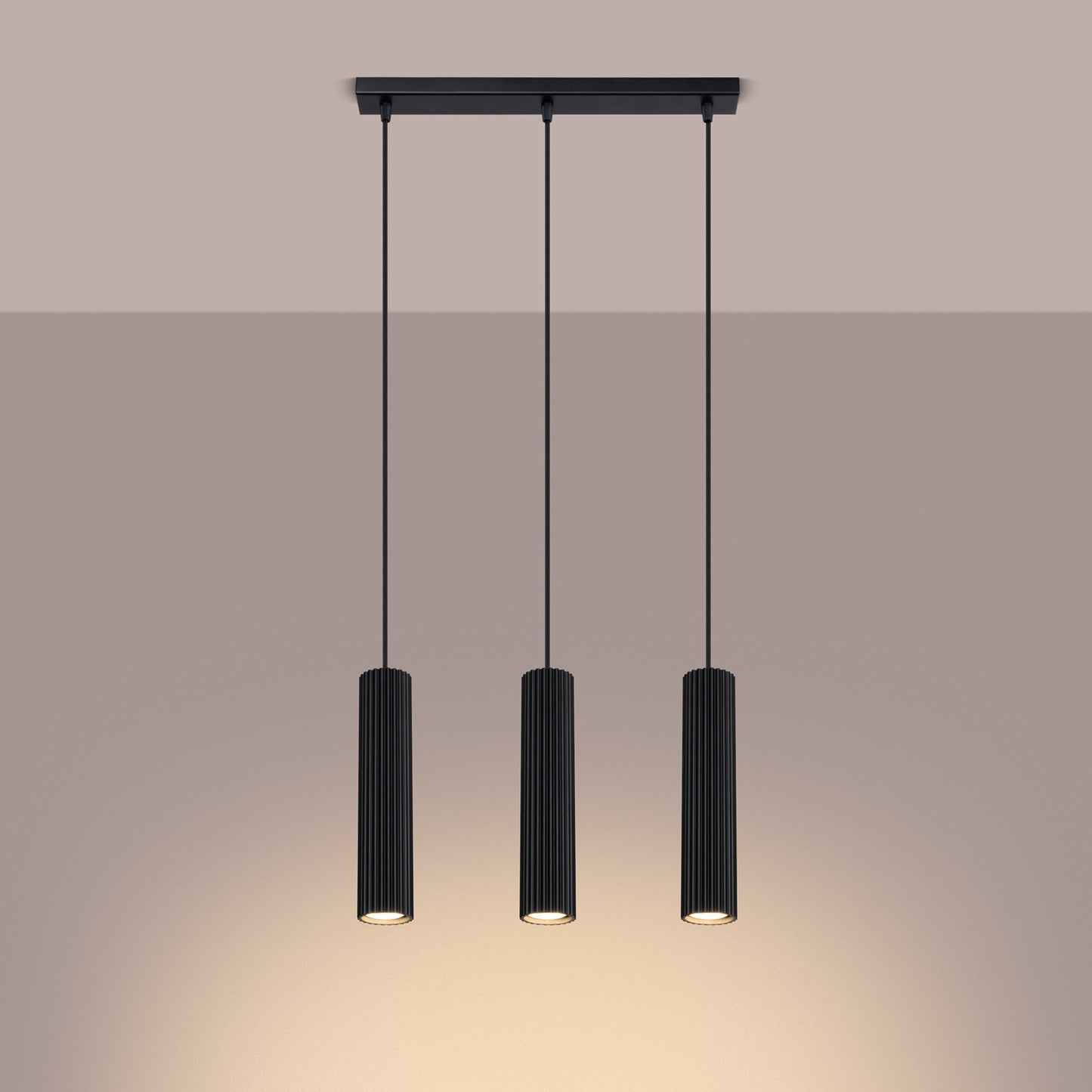 Black Triple Ribbed Pendant Bar switched on in modern UK home interior, warm LED glow