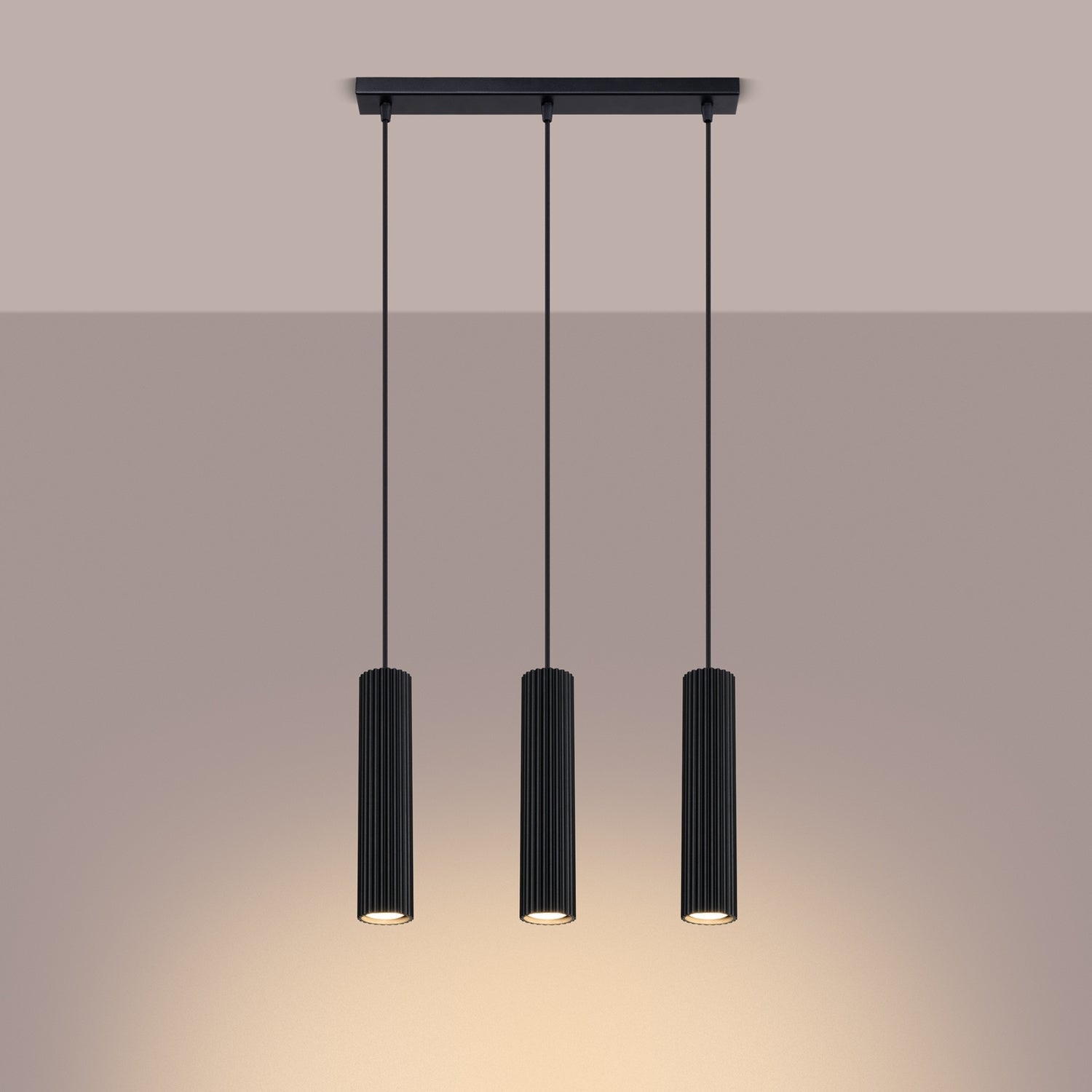 Black Triple Ribbed Pendant Bar switched on in modern UK home interior, warm LED glow