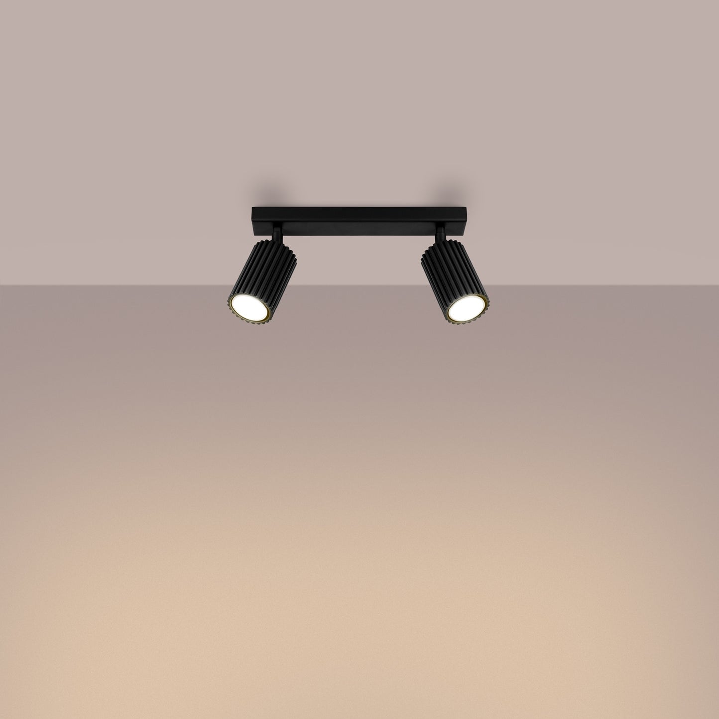 Black Twin Ribbed Surface Spotlight switched on in modern UK home interior, warm LED glow
