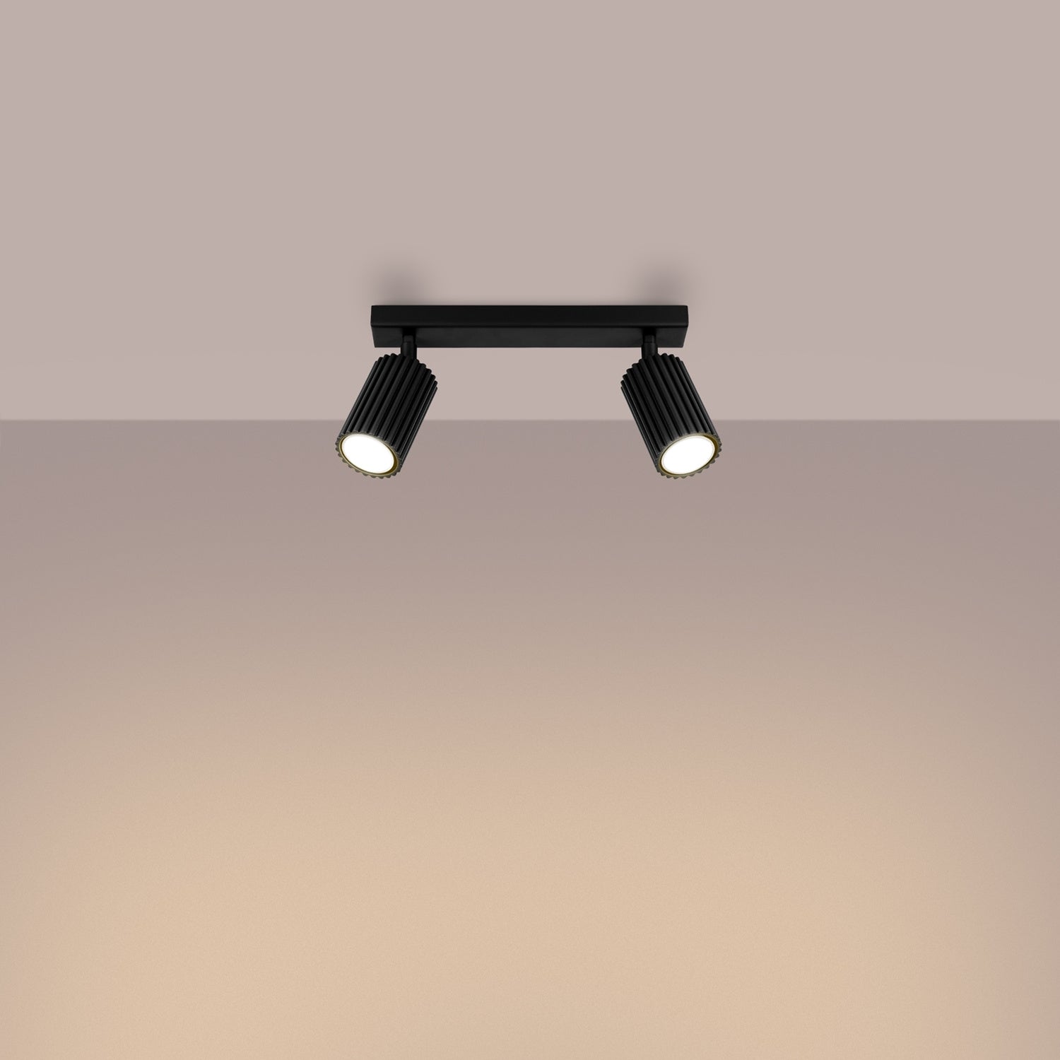 Black Twin Ribbed Surface Spotlight switched on in modern UK home interior, warm LED glow