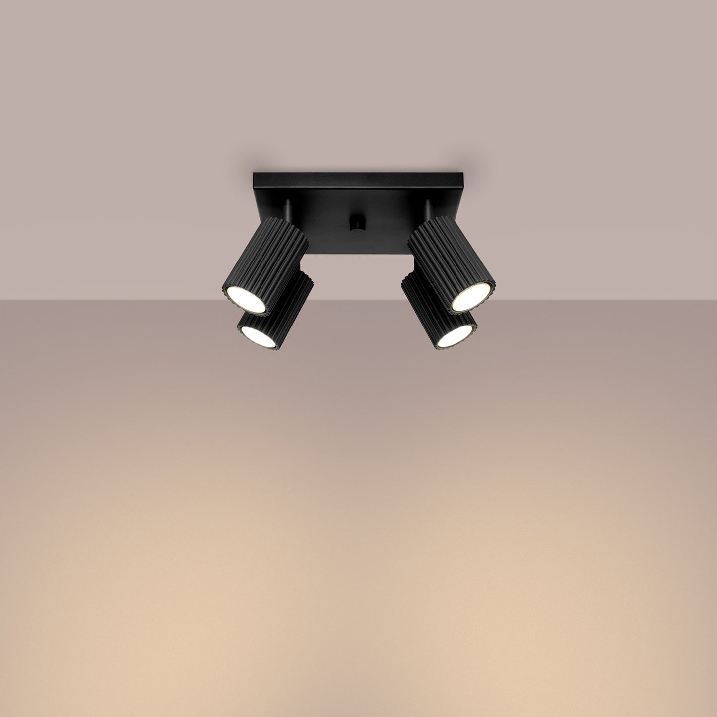 Black Quad Ribbed Spotlight Cluster switched on in modern UK home interior, warm LED glow