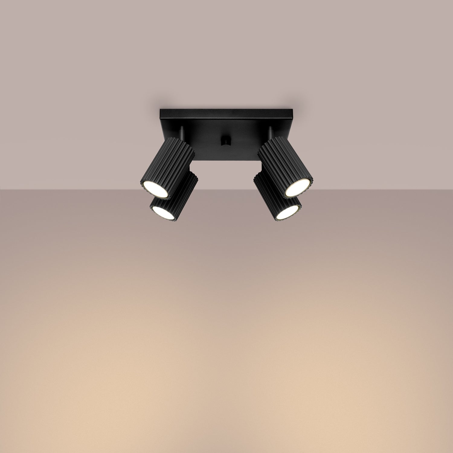Black Quad Ribbed Spotlight Cluster switched on in modern UK home interior, warm LED glow
