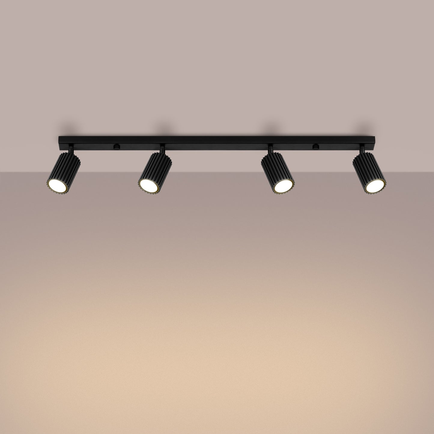 Black Four Light Ribbed Spotlight Bar switched on in modern UK home interior, warm LED glow