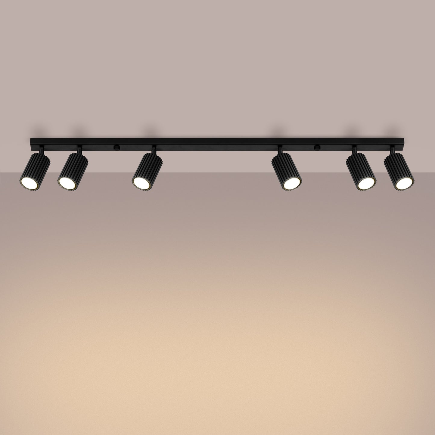 Black Six Light Ribbed Spotlight Bar switched on in modern UK home interior, warm LED glow