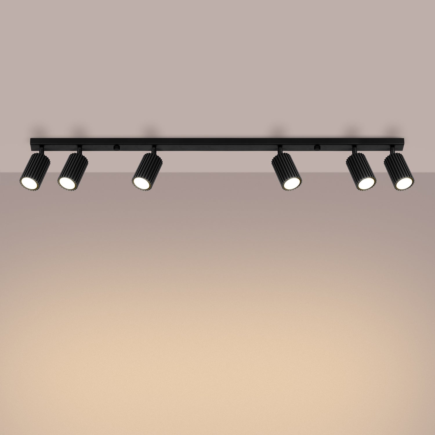 Black Six Light Ribbed Spotlight Bar switched on in modern UK home interior, warm LED glow