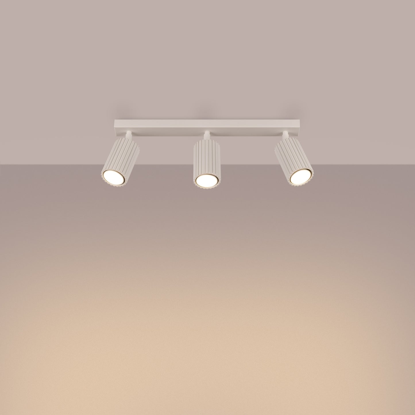 Beige Triple Ribbed Spotlight Bar switched on in modern UK home interior, warm LED glow