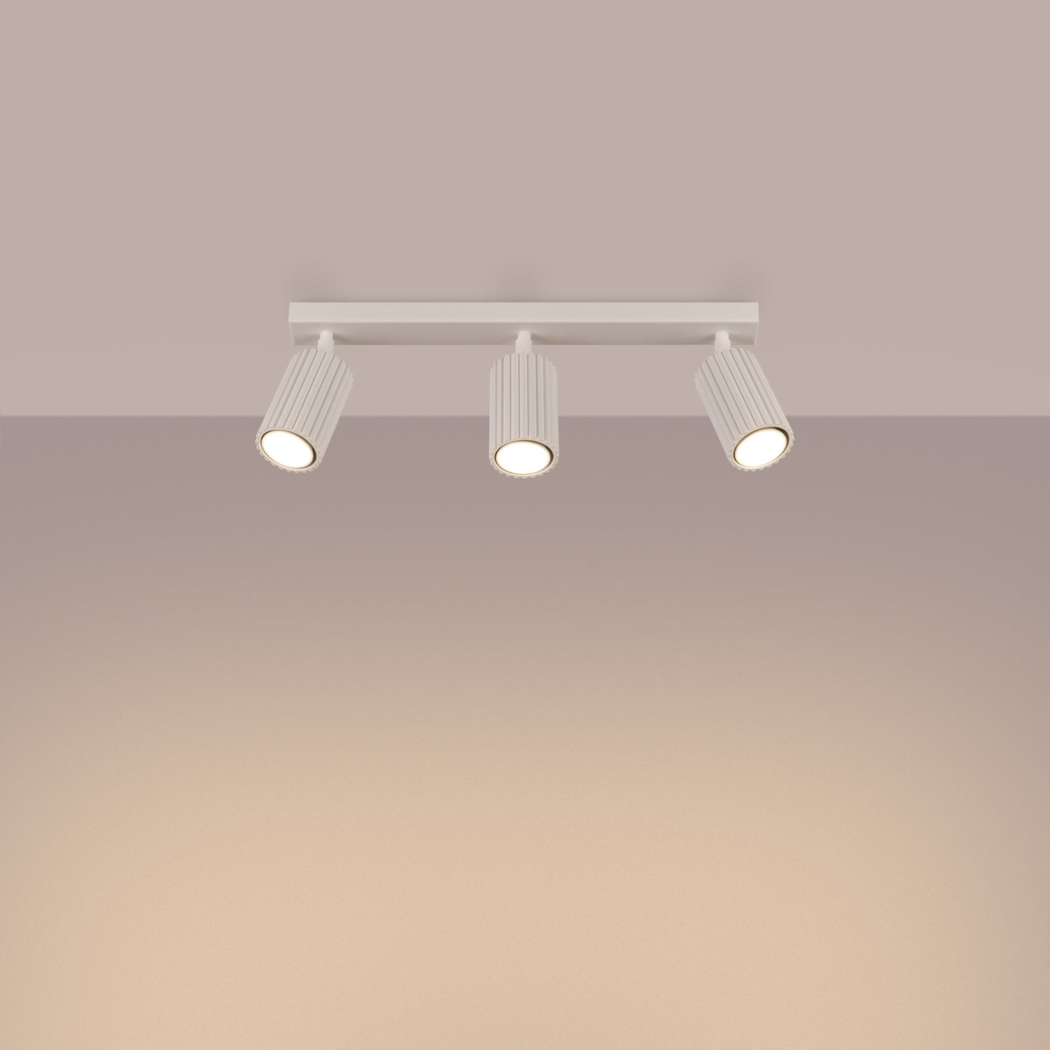 Beige Triple Ribbed Spotlight Bar switched on in modern UK home interior, warm LED glow