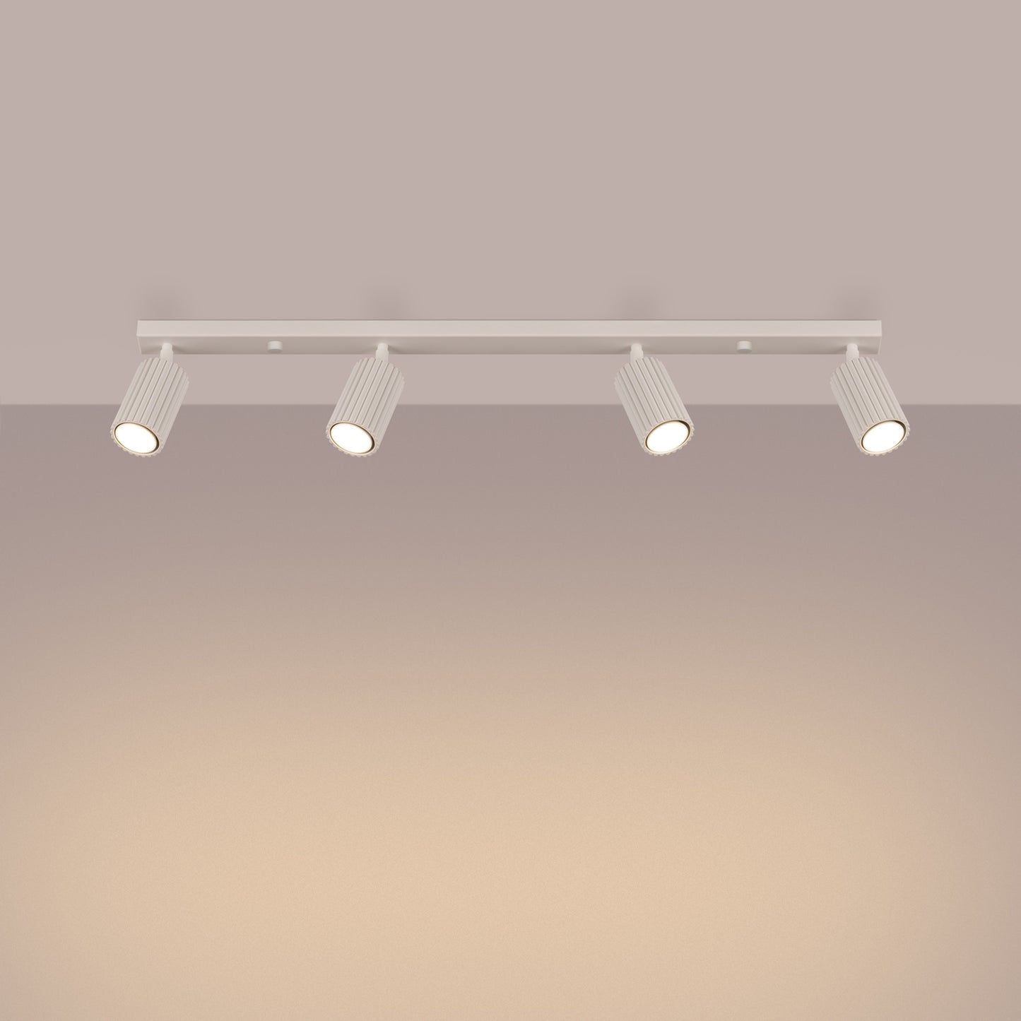Beige Four Light Ribbed Spotlight Bar switched on in modern UK home interior, warm LED glow