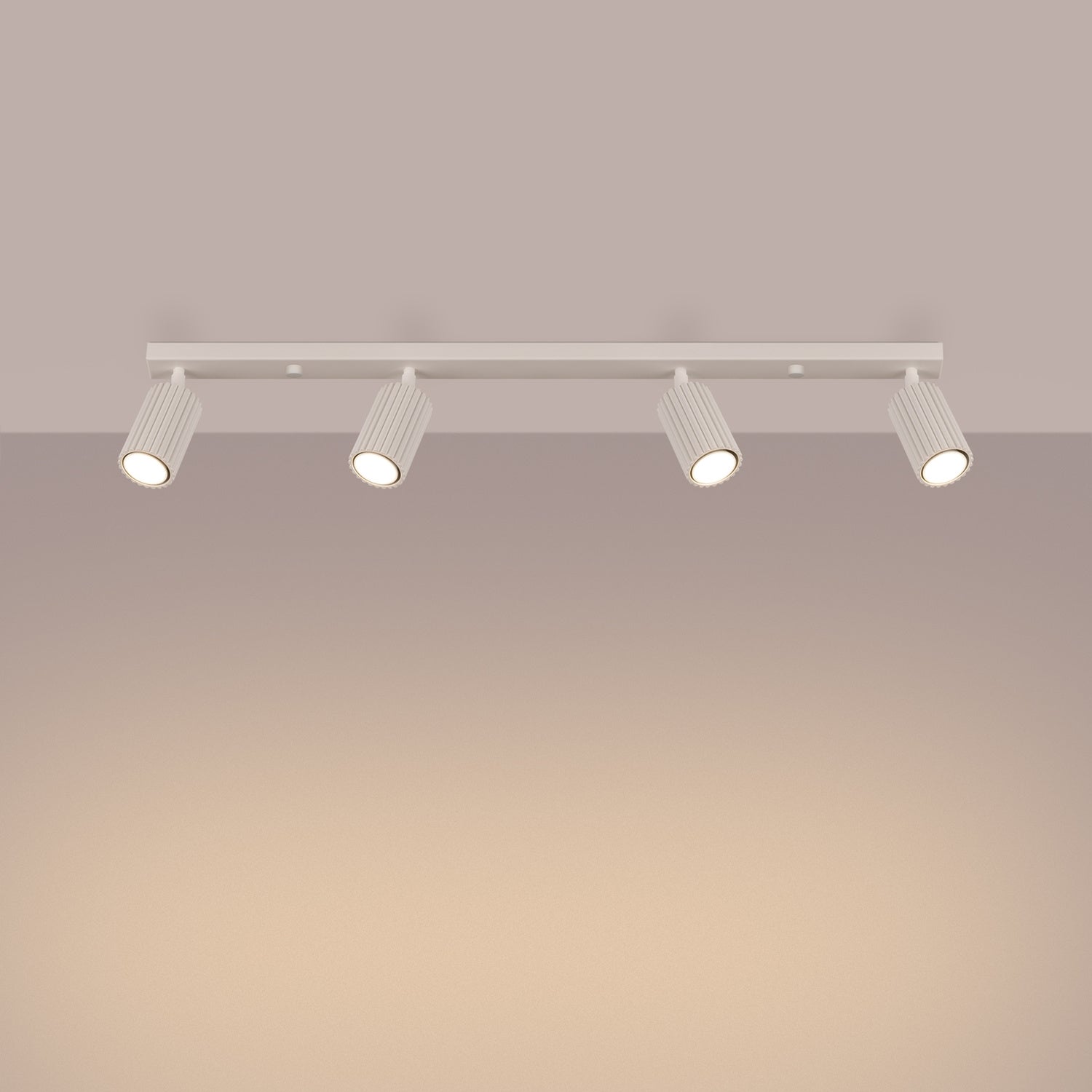Beige Four Light Ribbed Spotlight Bar switched on in modern UK home interior, warm LED glow