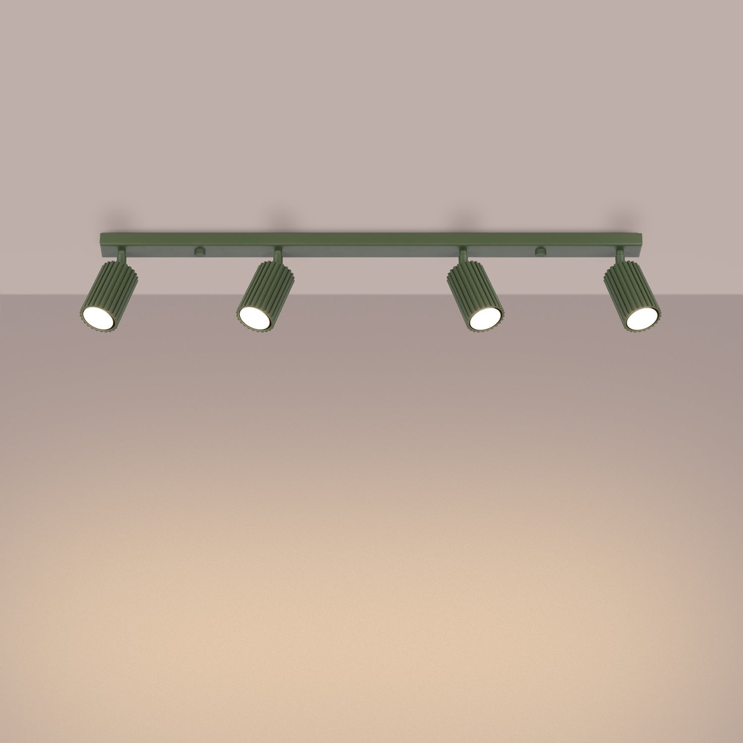 Olive Green Four Light Ribbed Spotlight Bar switched on in modern UK home interior, warm LED glow