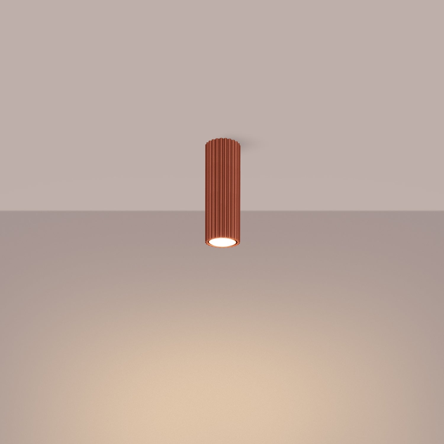 Red Ochre Ribbed Tube Ceiling Spotlight 20cm switched on in modern UK home interior, warm LED glow