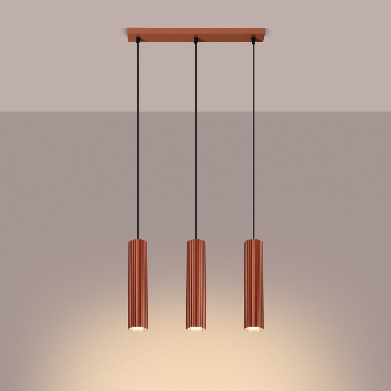 Red Ochre Triple Ribbed Pendant Bar switched on in modern UK home interior, warm LED glow