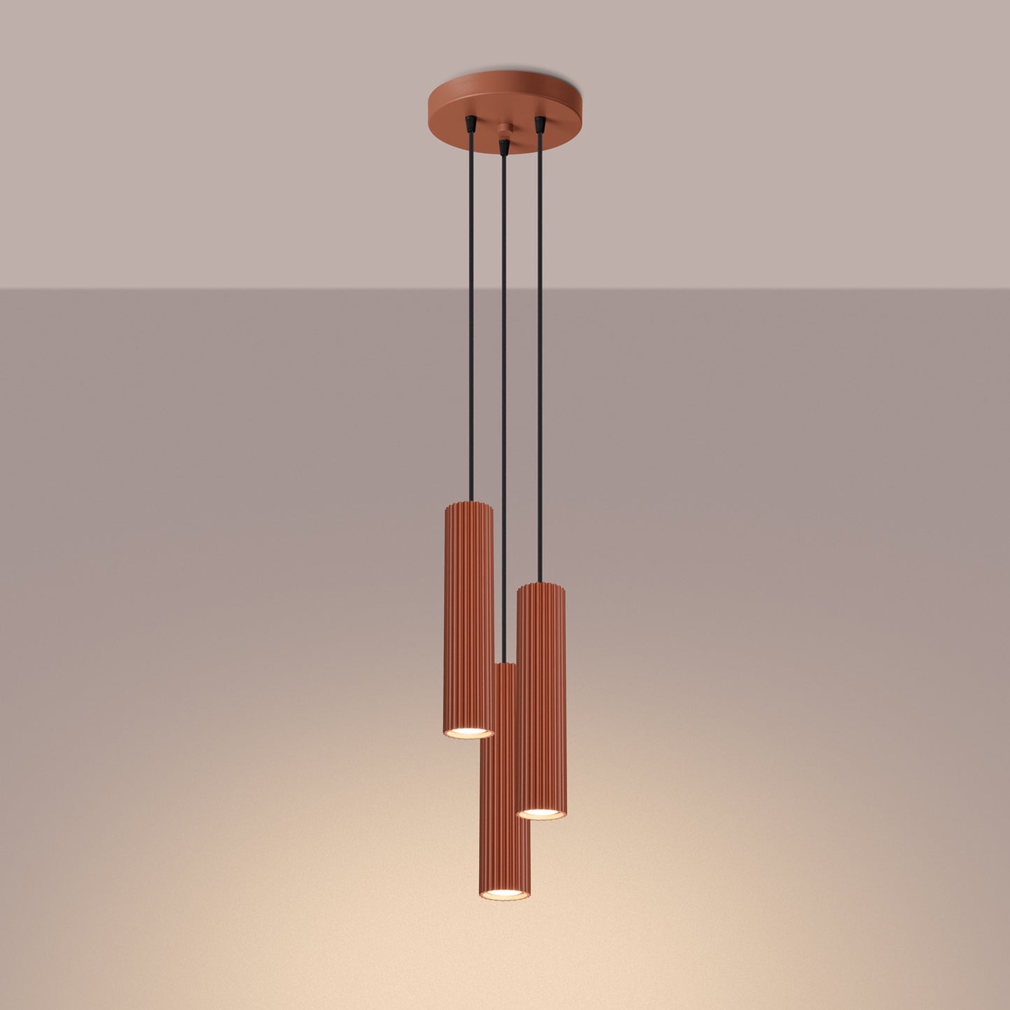 Red Ochre Triple Ribbed Pendant Cluster switched on in modern UK home interior, warm LED glow