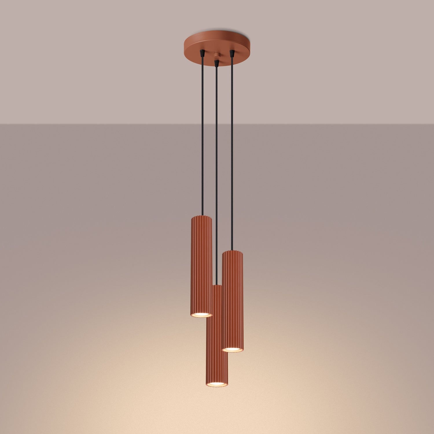 Red Ochre Triple Ribbed Pendant Cluster switched on in modern UK home interior, warm LED glow