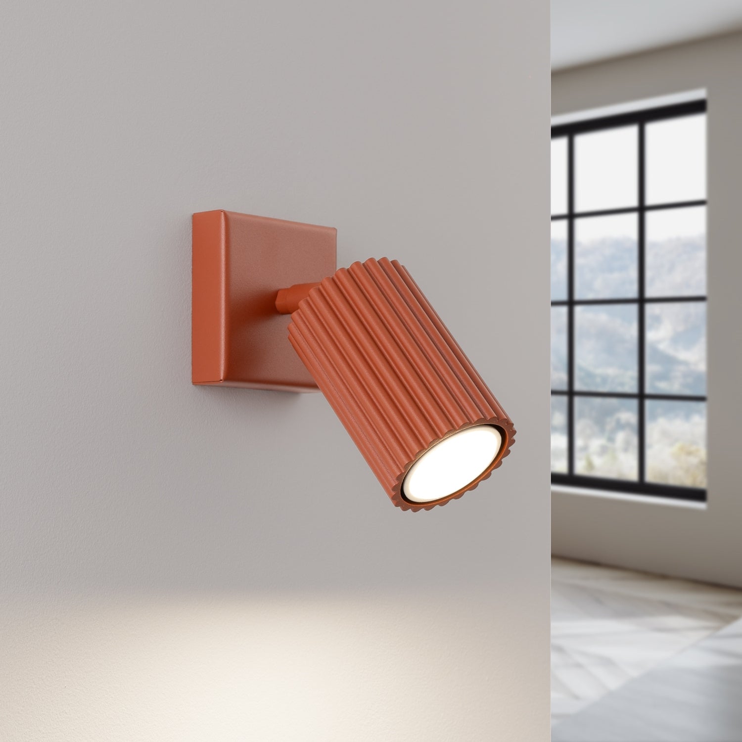 Red Ochre Ribbed Tube Wall Light switched on in modern UK home interior, warm LED glow
