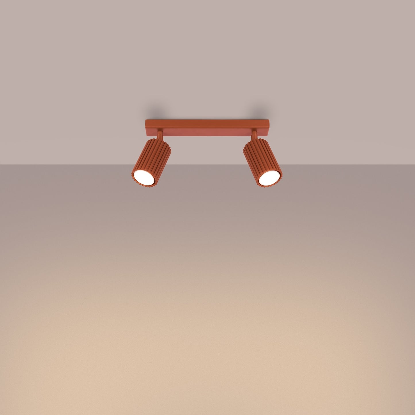 Red Ochre Twin Ribbed Surface Spotlight switched on in modern UK home interior, warm LED glow