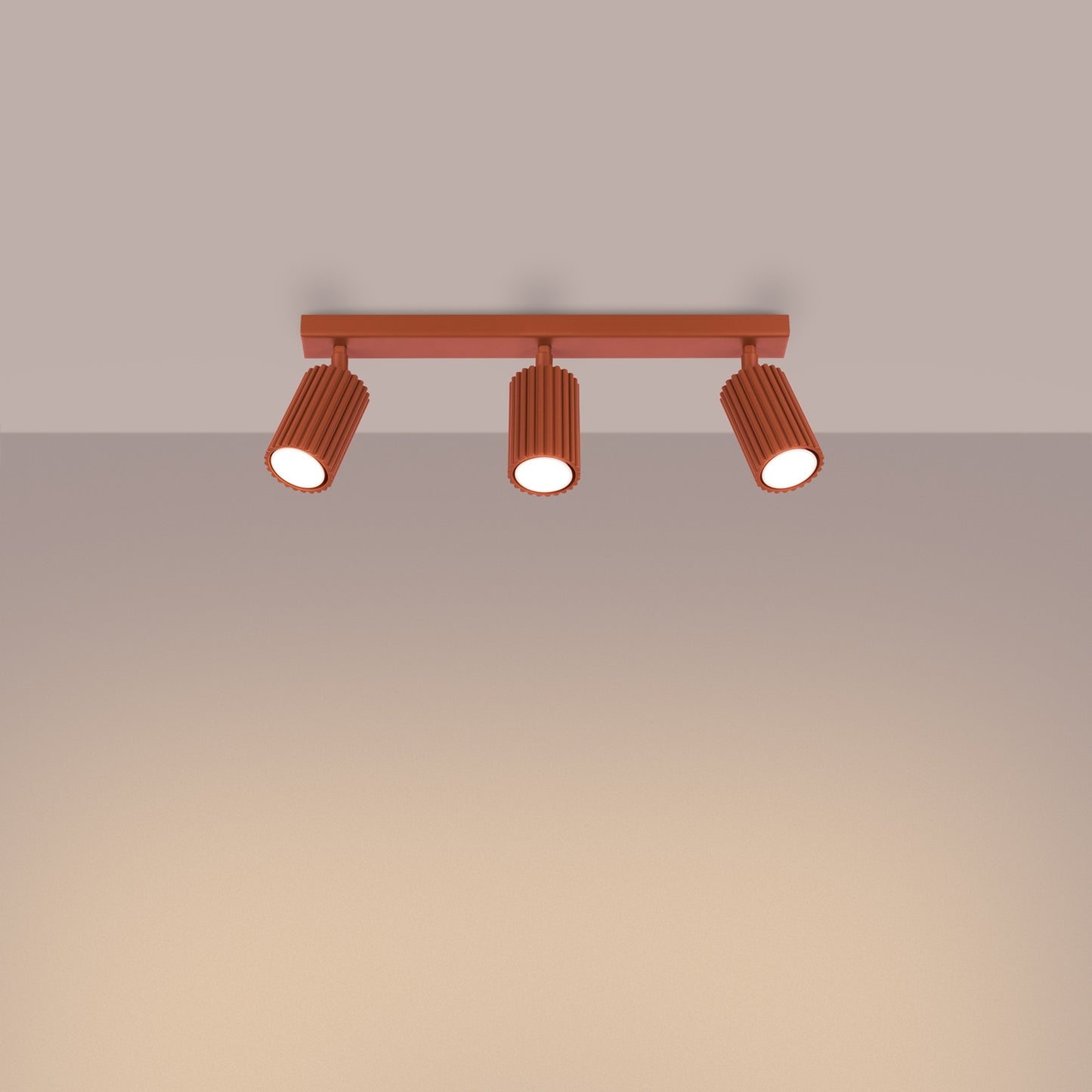 Red Ochre Triple Ribbed Spotlight Bar switched on in modern UK home interior, warm LED glow