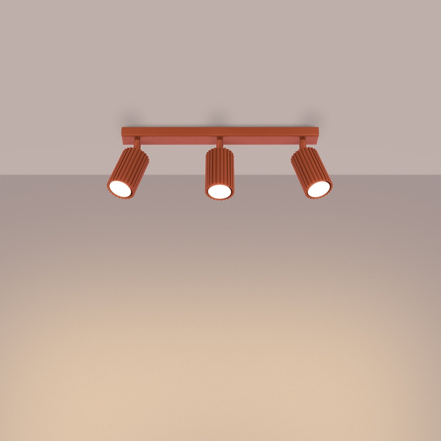 Red Ochre Triple Ribbed Spotlight Bar switched on in modern UK home interior, warm LED glow