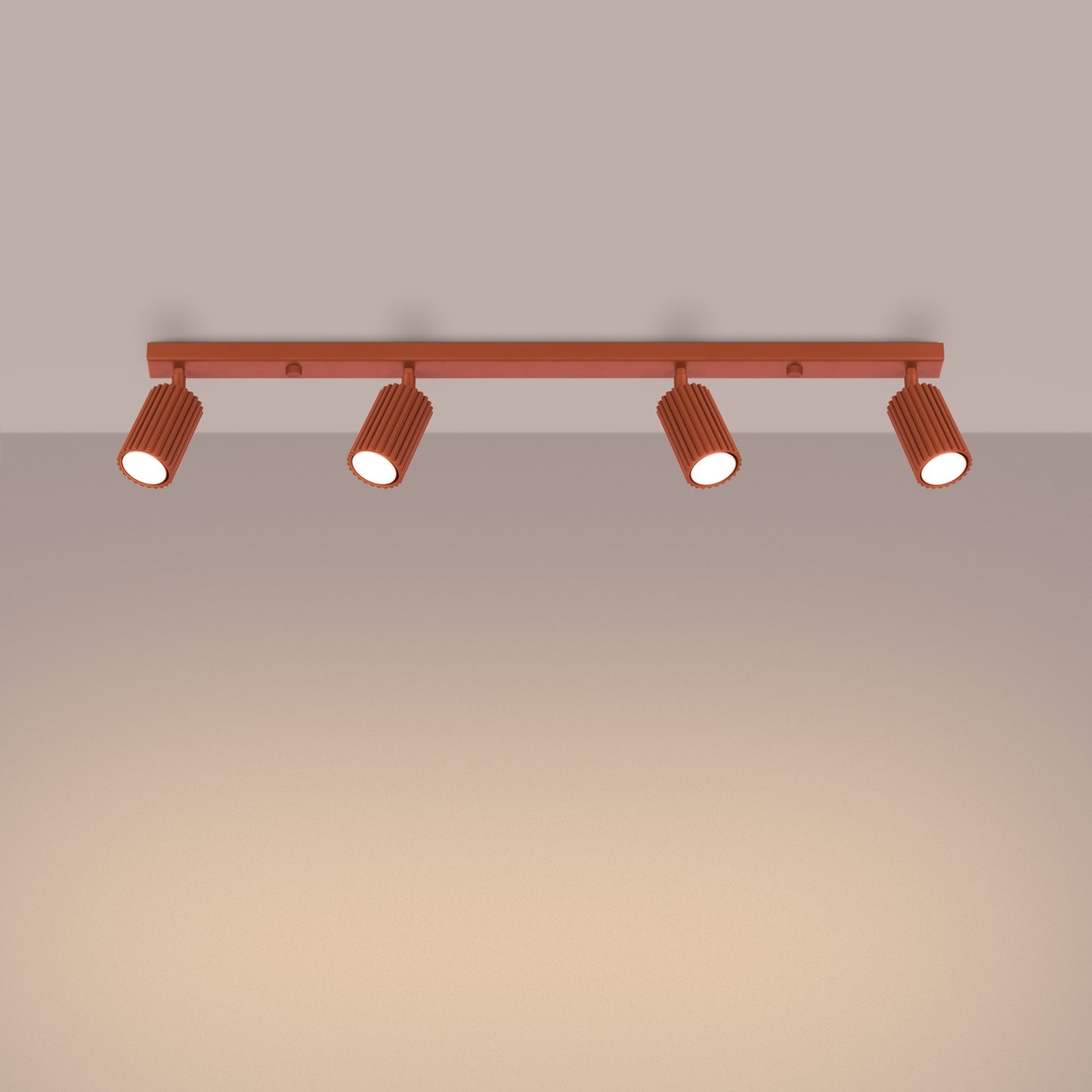 Red Ochre Four Light Ribbed Spotlight Bar switched on in modern UK home interior, warm LED glow