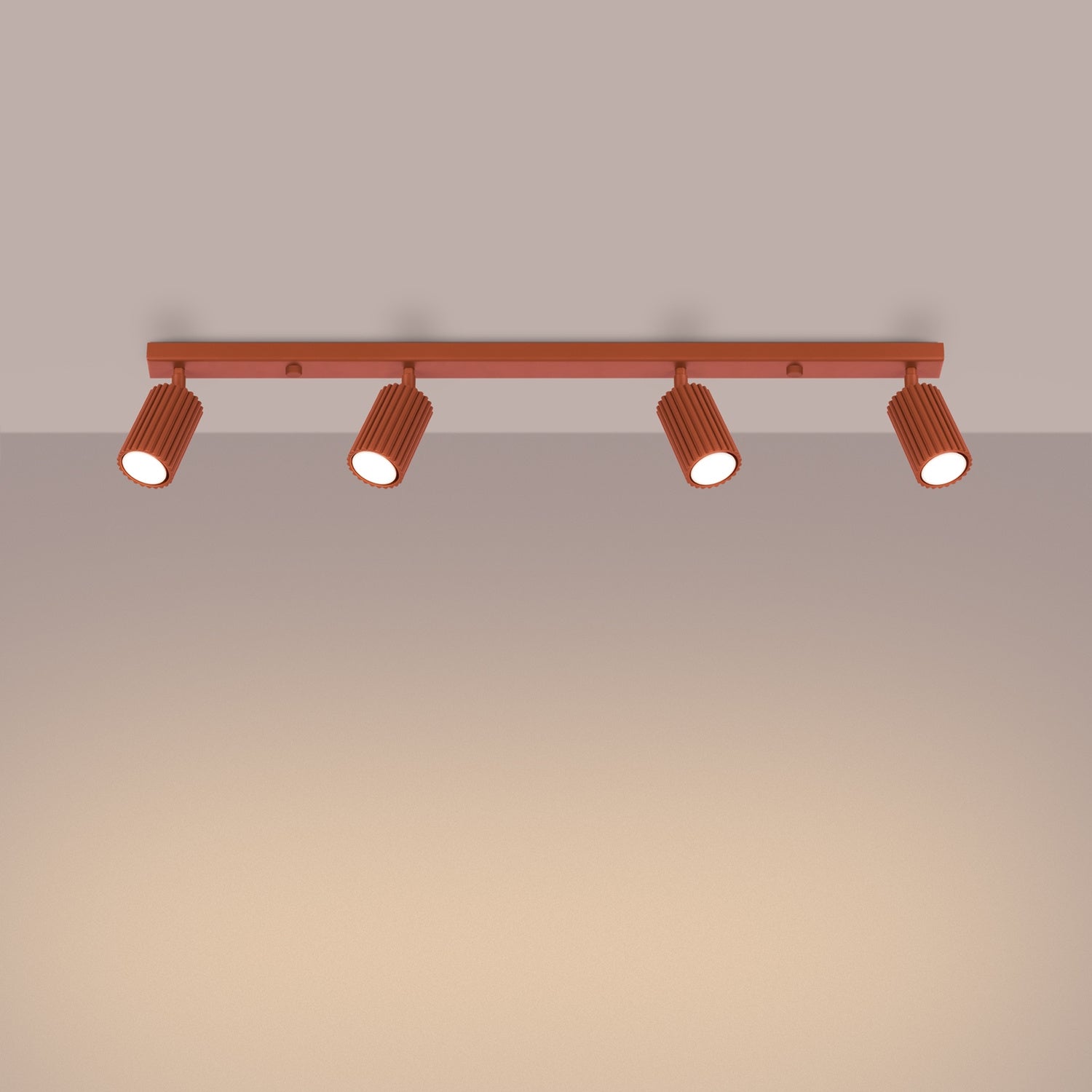 Red Ochre Four Light Ribbed Spotlight Bar switched on in modern UK home interior, warm LED glow