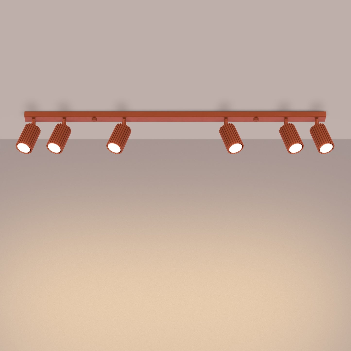 Red Ochre Six Light Ribbed Spotlight Bar switched on in modern UK home interior, warm LED glow