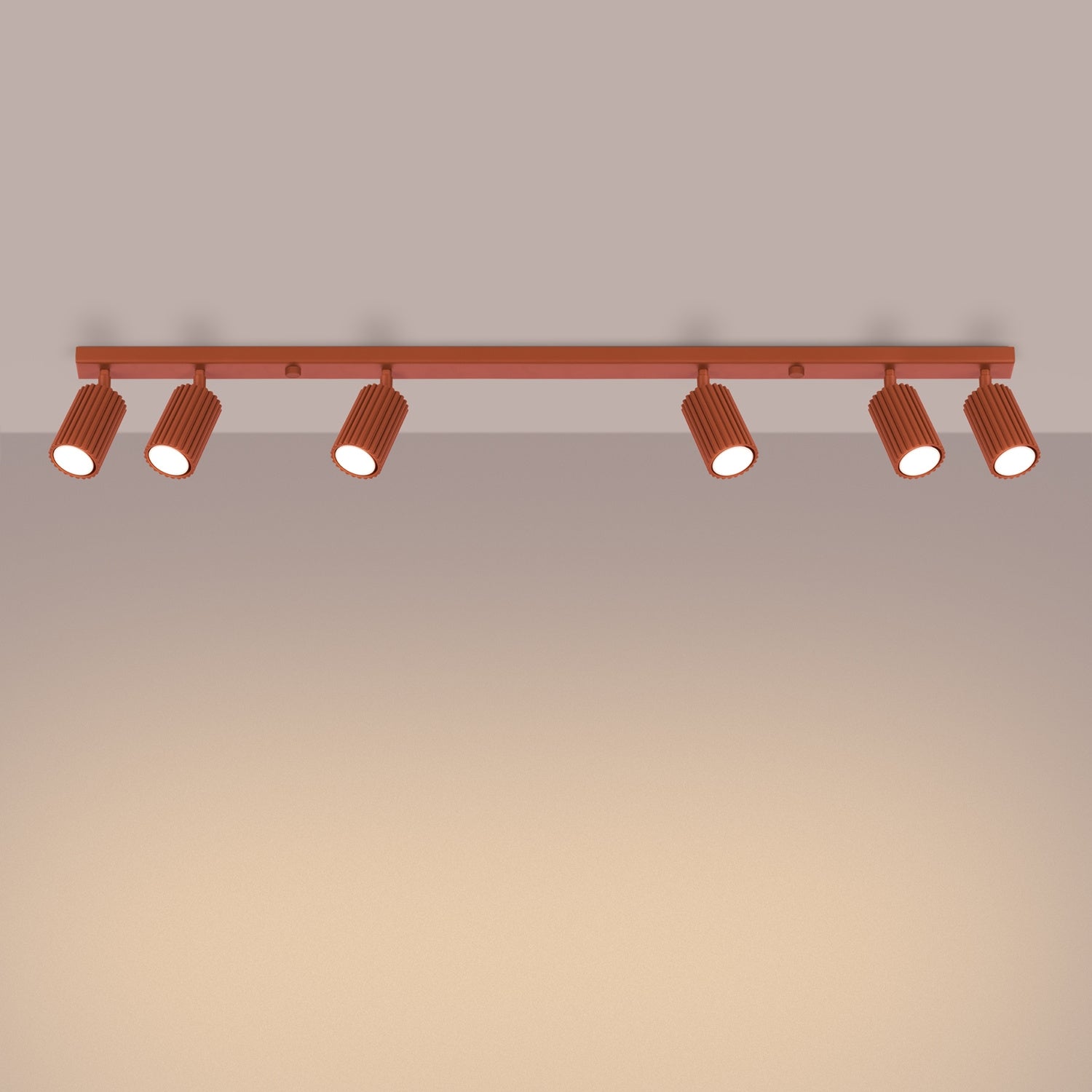 Red Ochre Six Light Ribbed Spotlight Bar switched on in modern UK home interior, warm LED glow