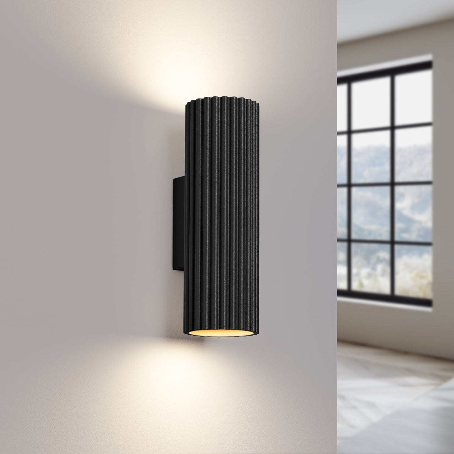 Black Ribbed Up Down Wall Light switched on in modern UK home interior, warm LED glow