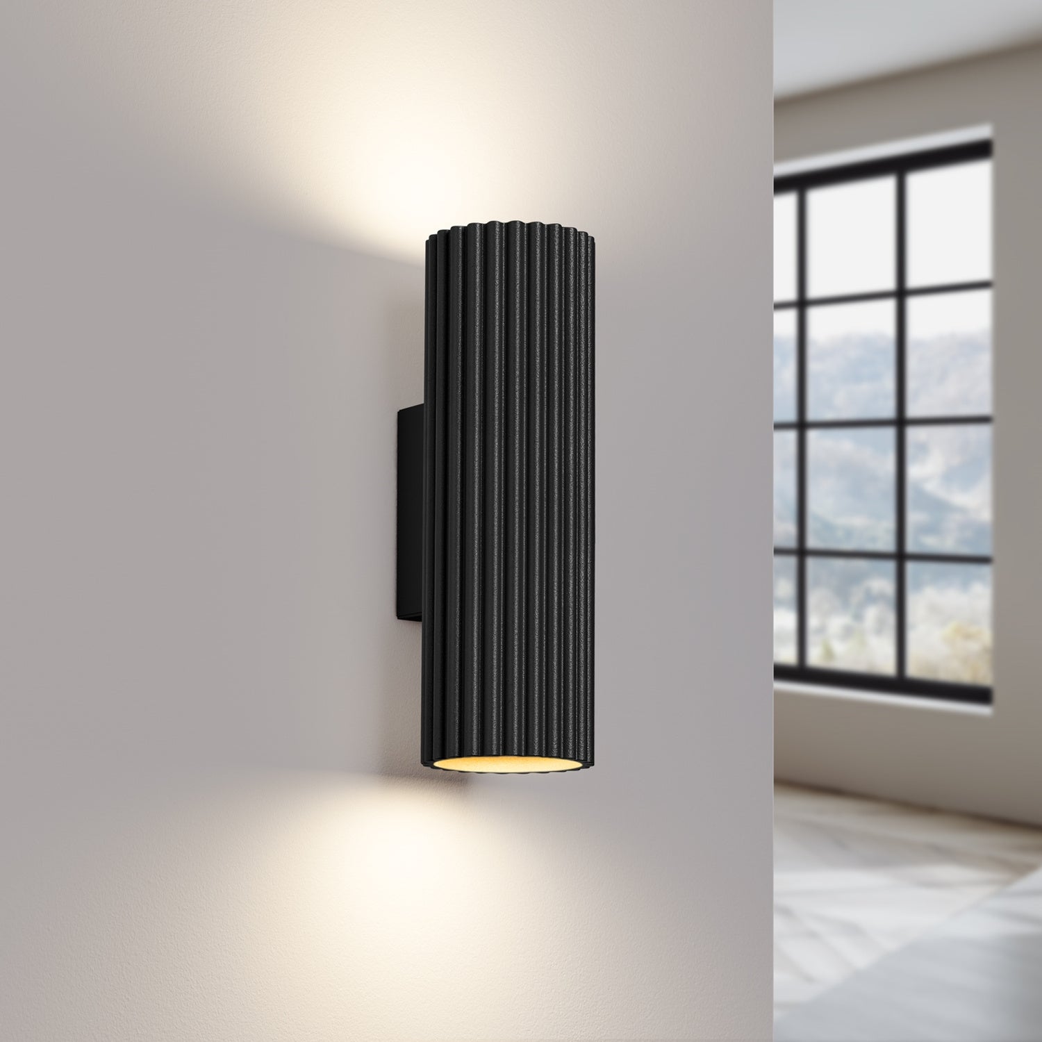 Black Ribbed Up Down Wall Light switched on in modern UK home interior, warm LED glow