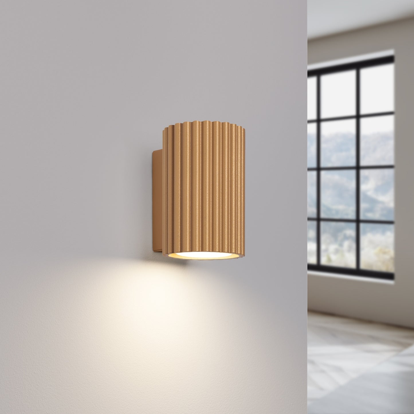 Gold Mini Ribbed Cylinder Wall Light switched on in modern UK home interior, warm LED glow