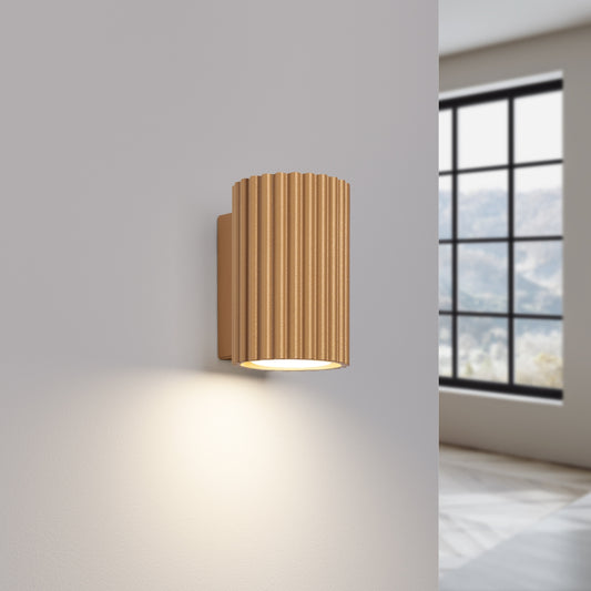 Gold Mini Ribbed Cylinder Wall Light switched on in modern UK home interior, warm LED glow