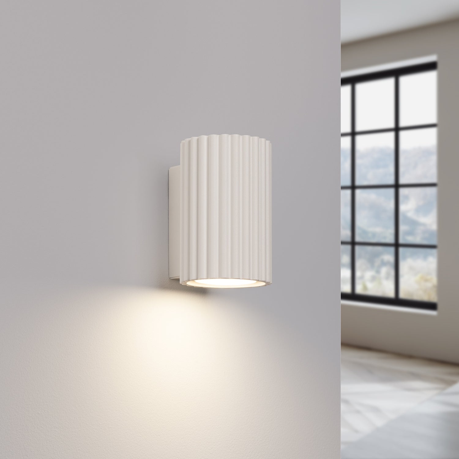 Beige Mini Ribbed Cylinder Wall Light switched on in modern UK home interior, warm LED glow