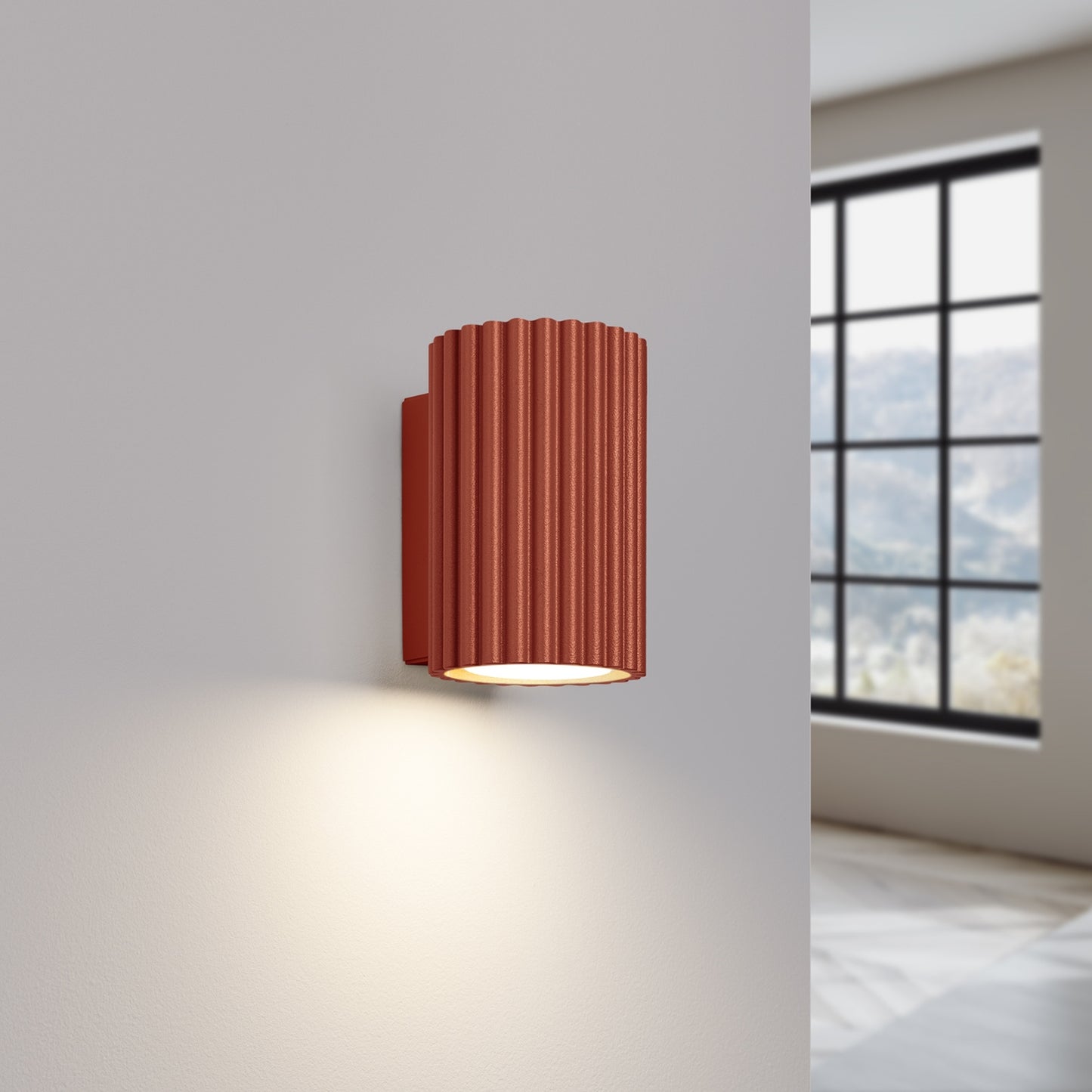 Red Ochre Mini Ribbed Cylinder Wall Light switched on in modern UK home interior, warm LED glow