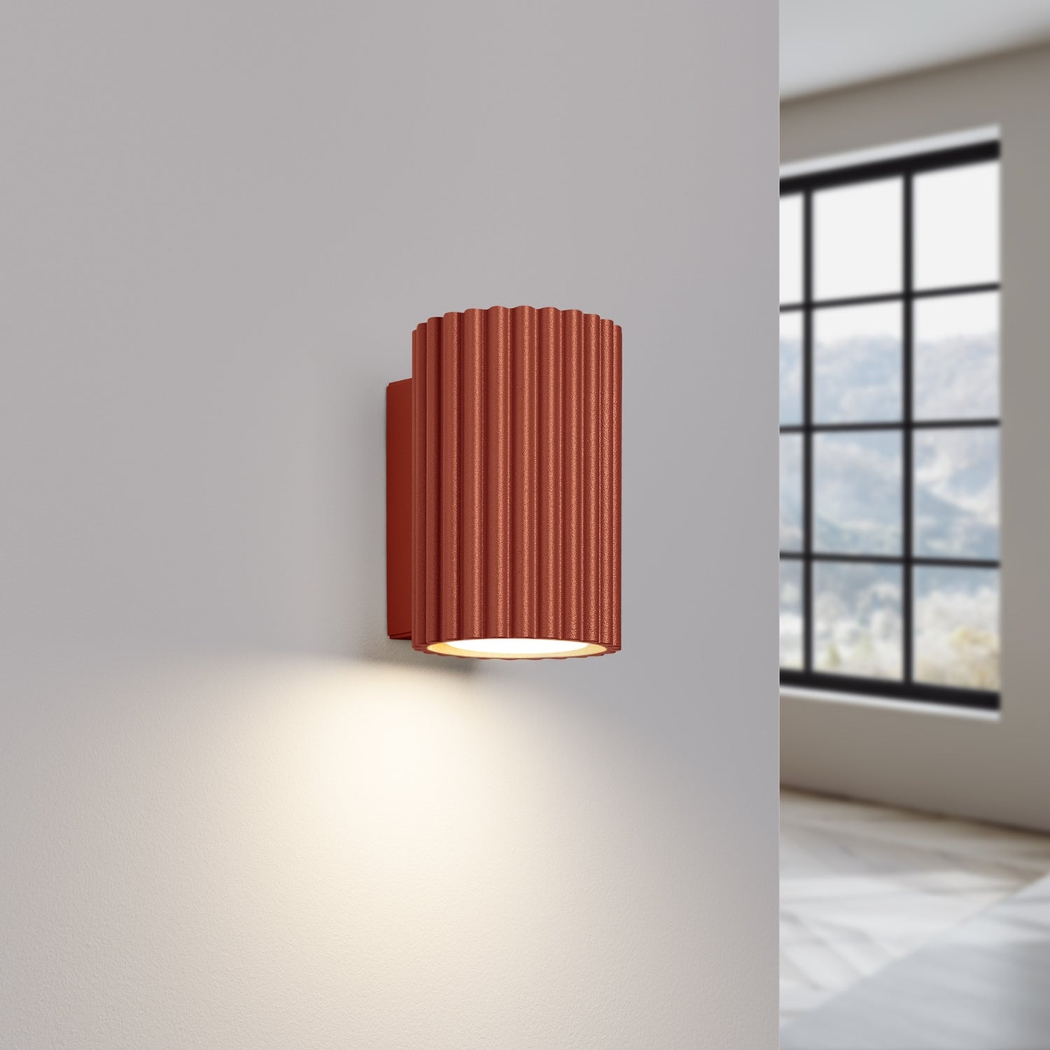Red Ochre Mini Ribbed Cylinder Wall Light switched on in modern UK home interior, warm LED glow